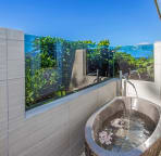 West master bathroom outdoor area with natural stone Balinese soaker tub