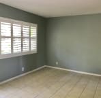 Bedroom with full wall closet and door to backyard.