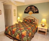 Master bed with island theme, coral end tables, remote control air, phone, clock