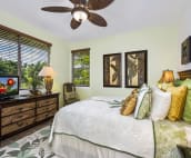 Main floor bedroom with queen bed decorated in a serene coconut palm motif.