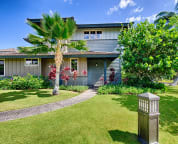 Front view of villa with beautiful tea trees, palm and sea grape trees.