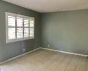 Bedroom with full wall closet and door to backyard.