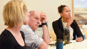 Dr. Fernando Holguin sits at a conference table, his hand to forehead, listening intently about the preliminary study results. 