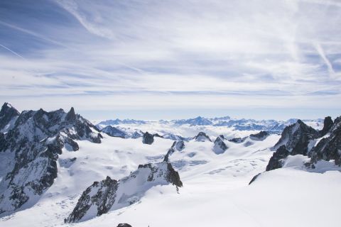 Austrian alps mountain peaks under a blue sky and partially covered by clouds