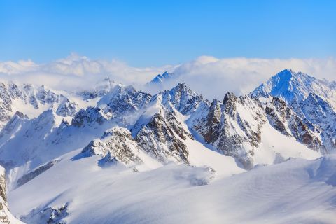 Scenic snow-capped mountains with visible protective snow barriers along the slopes.