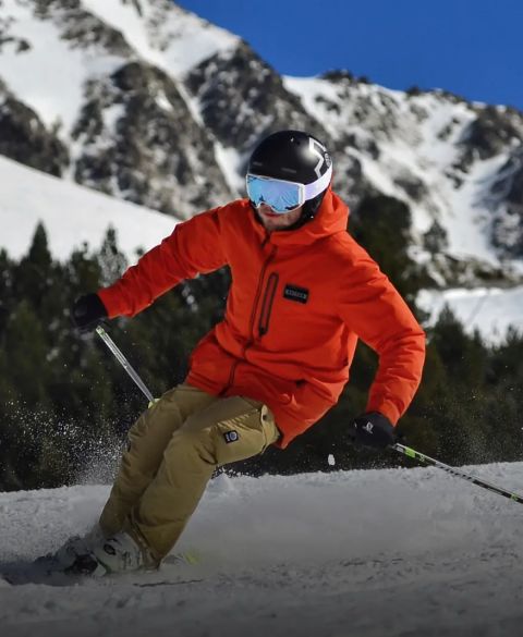 Beginner skier skiing down a snowy slope with mountains in the background