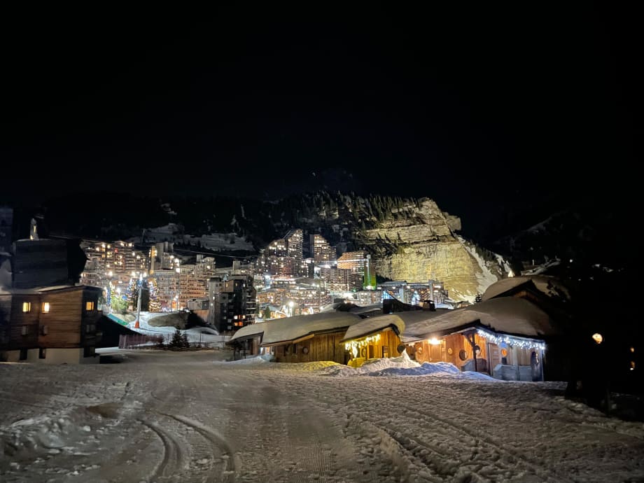 The timber buildings of Avoriaz lit up against the dark, seen across the snow at night