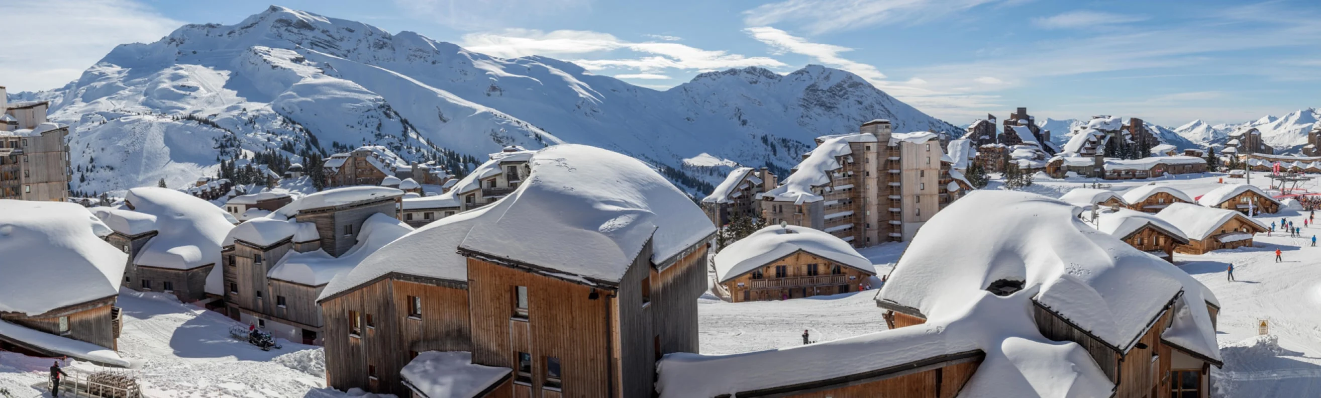Avoriaz ski resort with wooden chalets and snow-covered buildings, set against a backdrop of snow-capped mountains