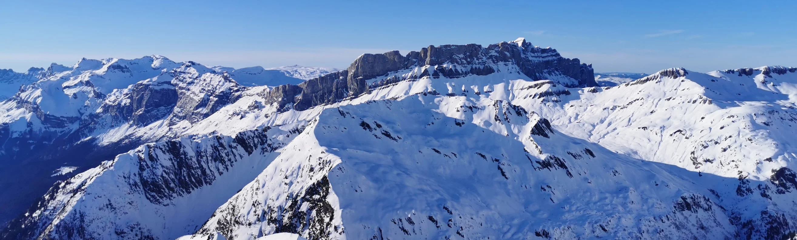 Snow-covered French Alps peaks in winter with clear blue skies