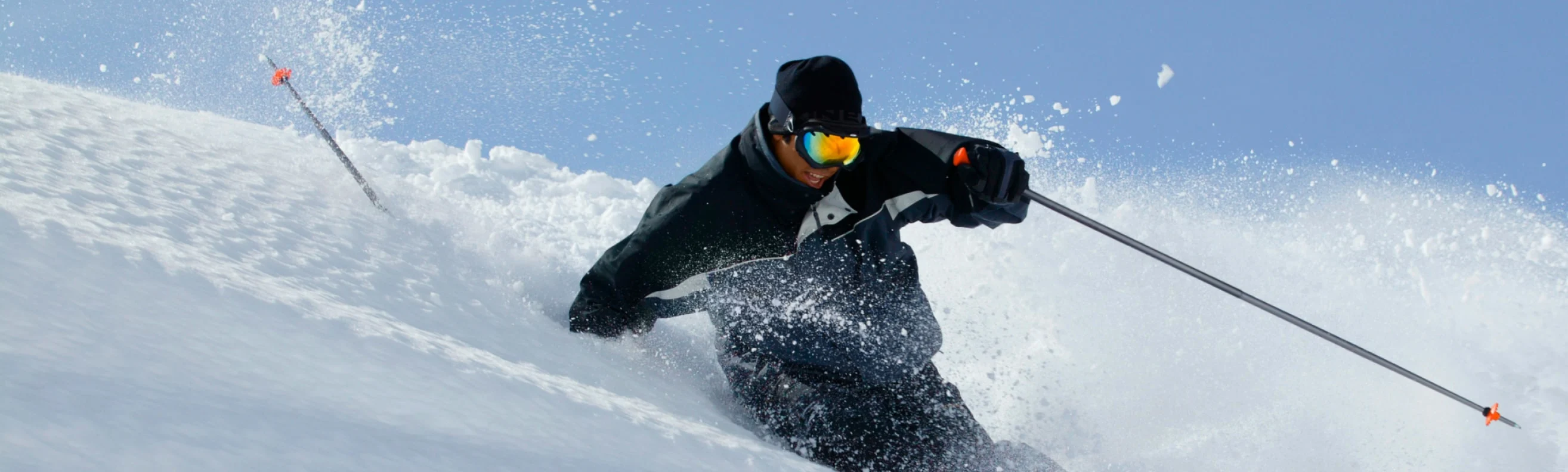 Skier carving through fresh powder on a sunny day in the Italian Alps
