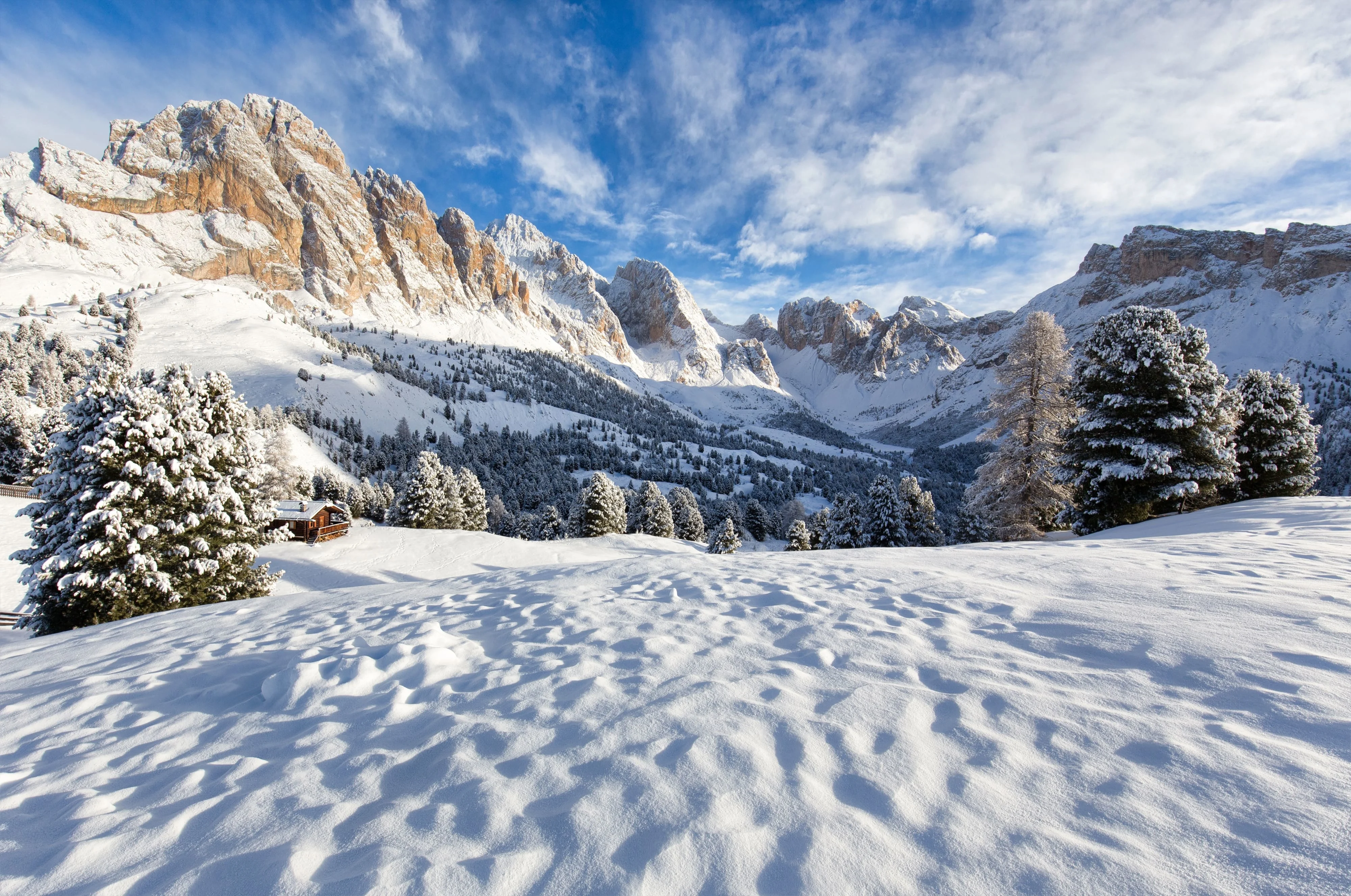 An expansive snow-covered mountain range with clear blue skies, showcasing the grandeur of the alpine landscape