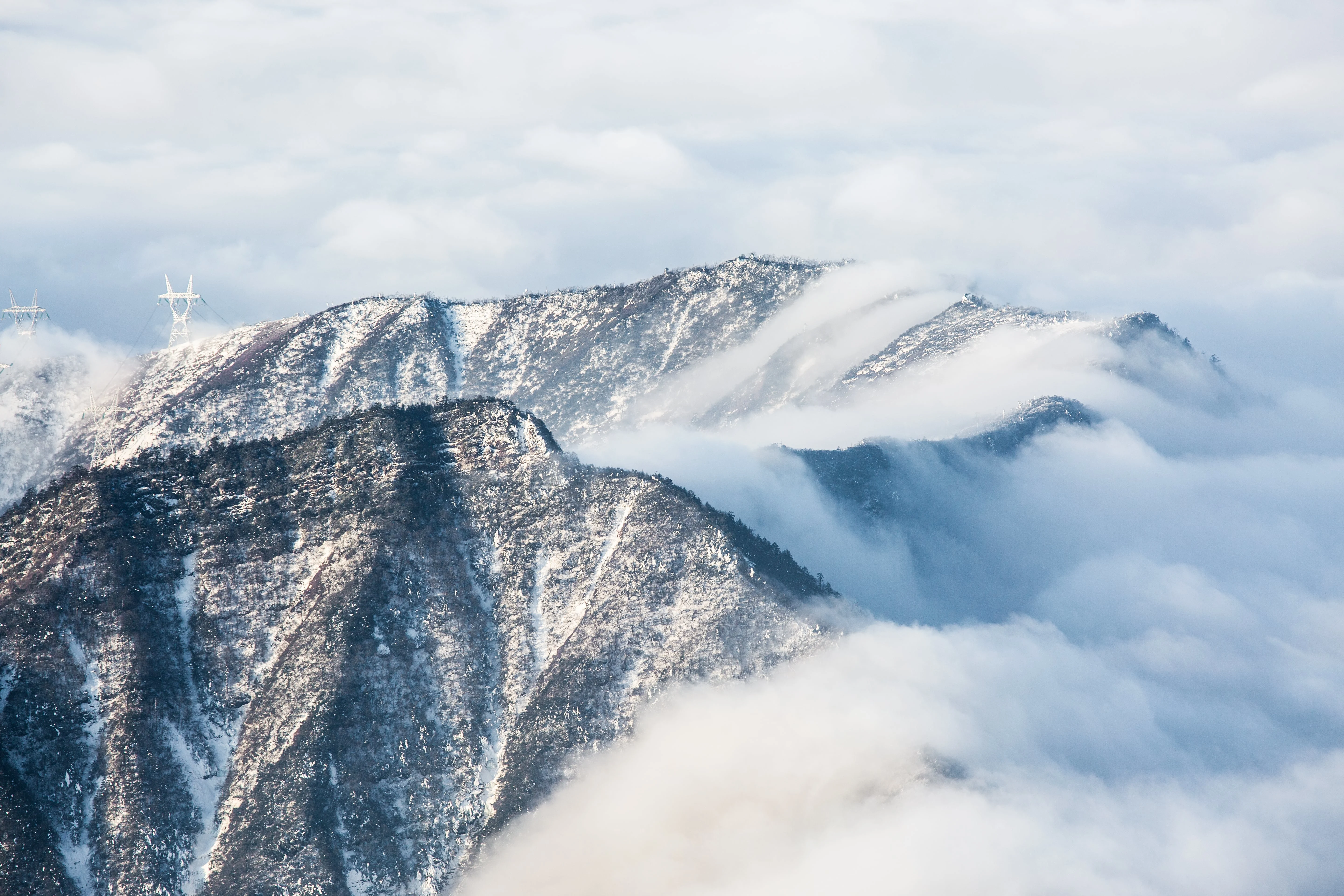 Snowy mountain ridge with clouds drifting over the peaks