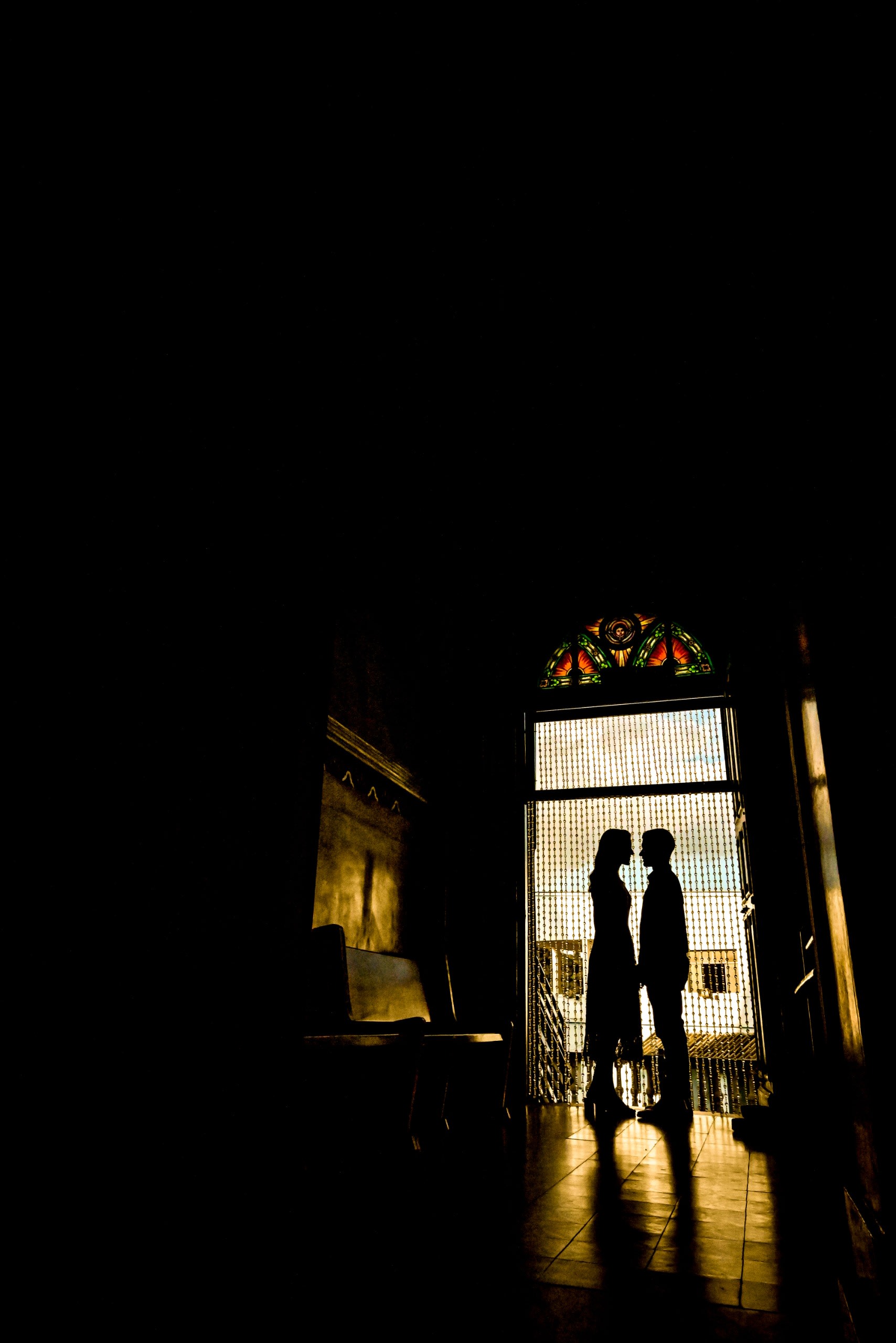 Lucas e Rafaela em silhueta na porta da igreja