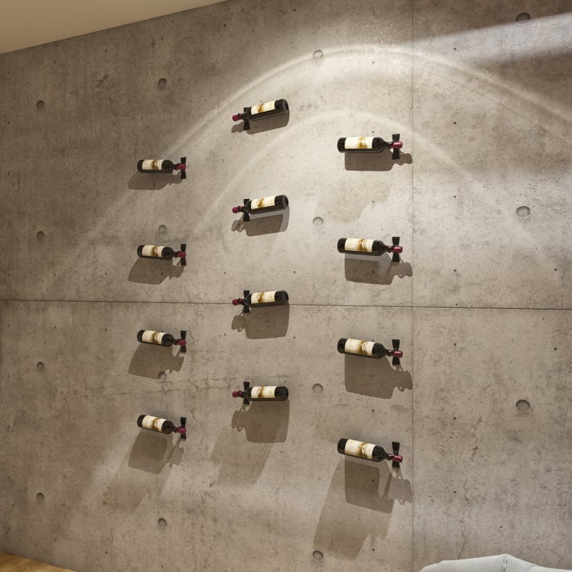 Wine bottles attached to a concrete wall in a spread-out arrangement