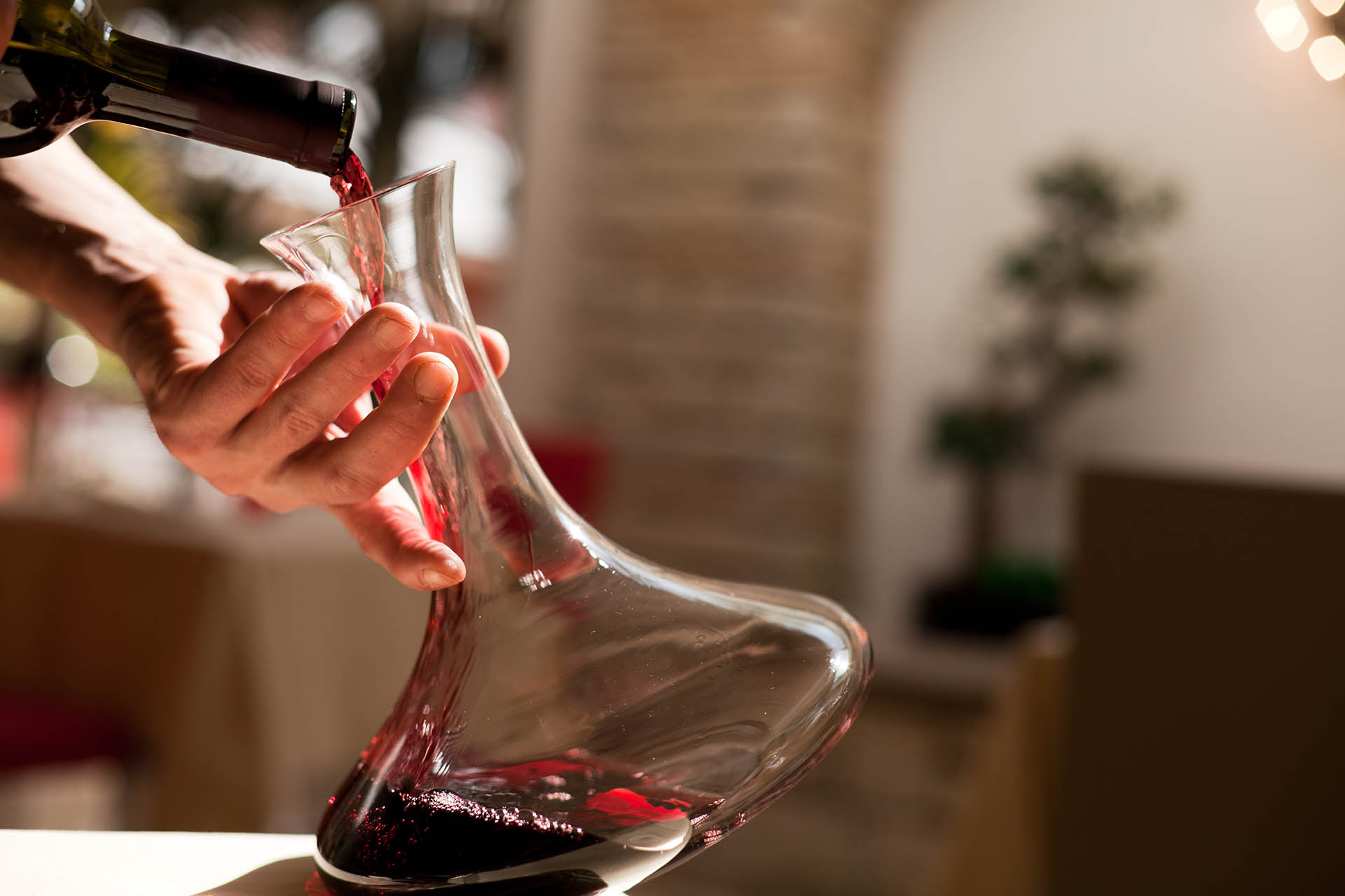 Red wine being poured into decanter