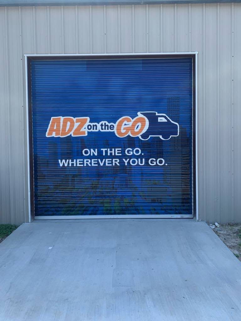 Vinyl graphics applied across a segmented commercial shutter
