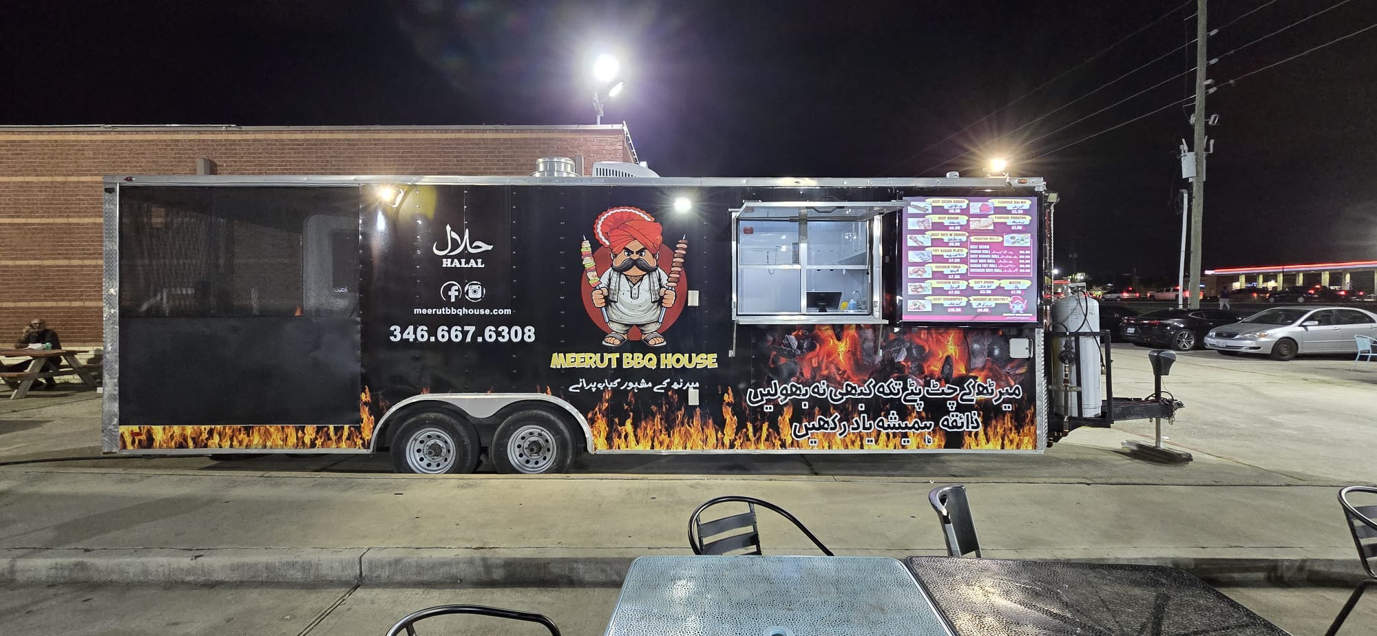 Evening photo of a wrapped BBQ house food trailer