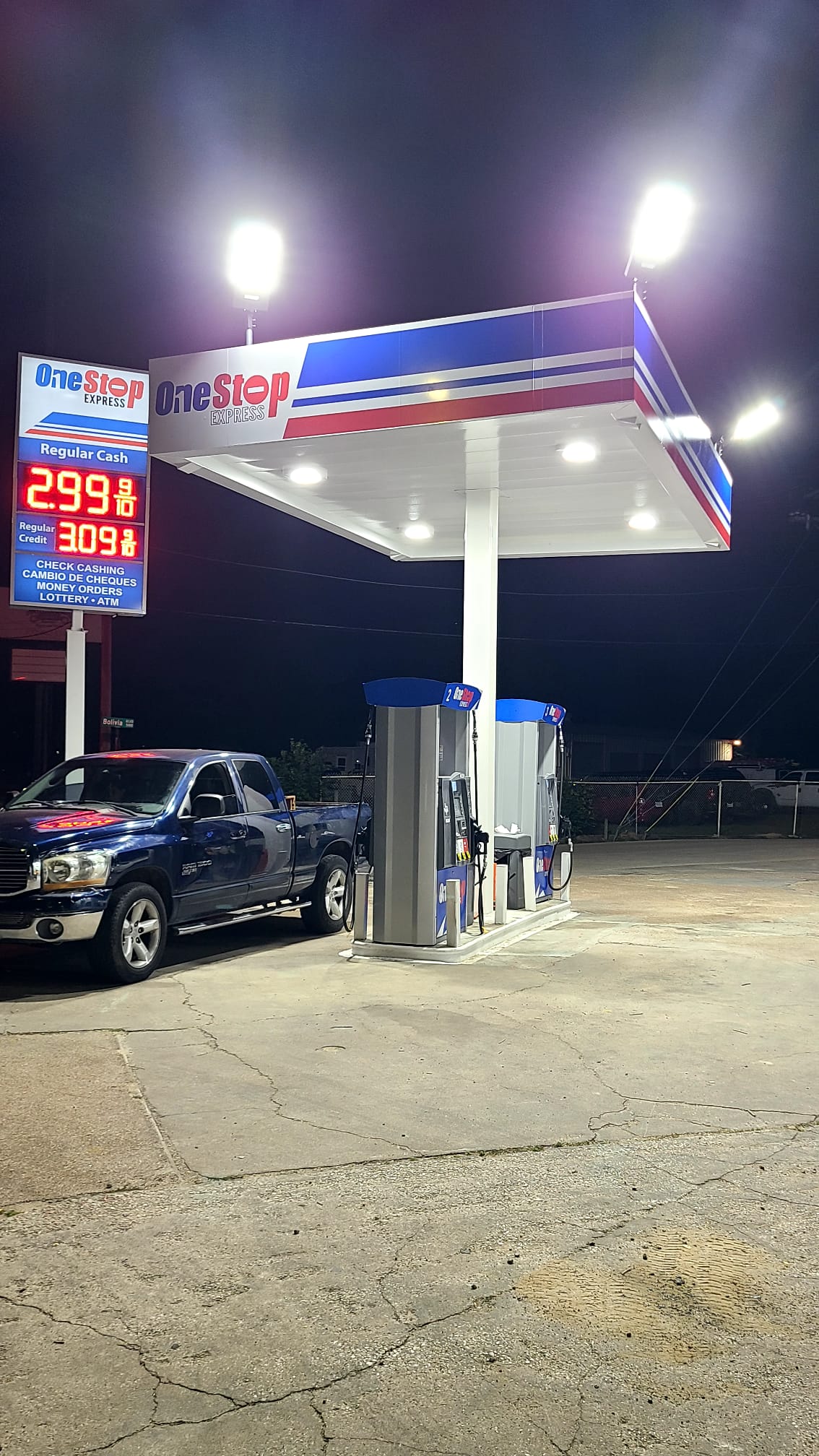 Illuminated gas station canopy and matching roadside pylon at night
