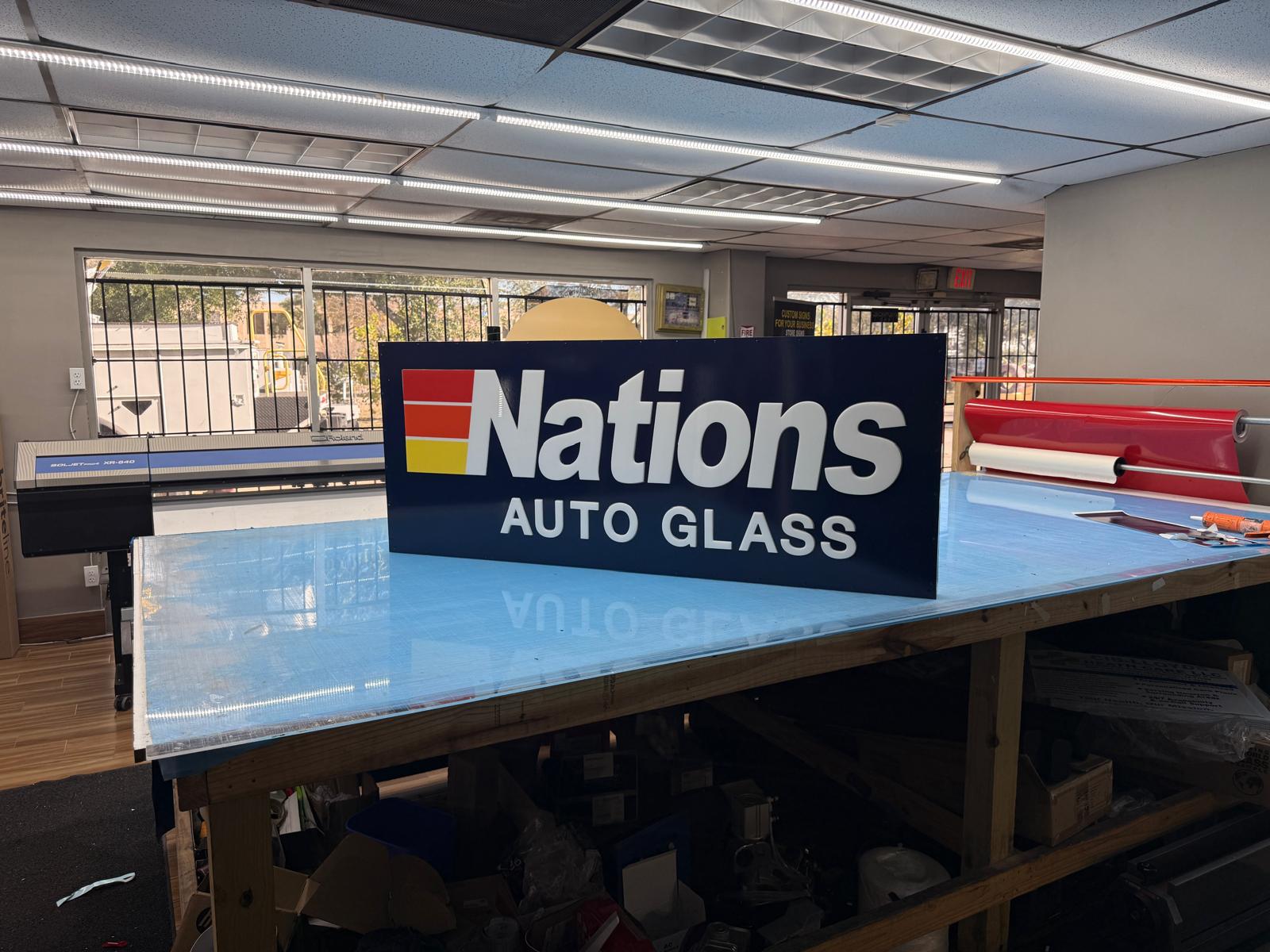 Fabricated auto glass sign panel resting in the shop