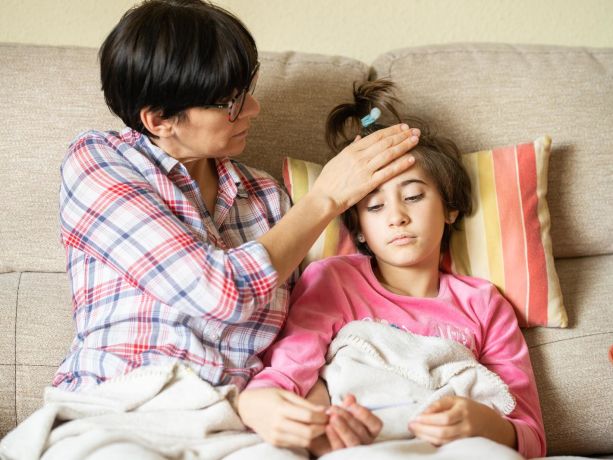 ateşi olan ağrısı olan bir çocuk ve annesi ateşini ölçüyor