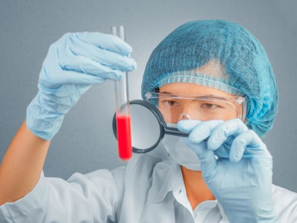 kan tahlili inceleyen bir sağlık görevlisi