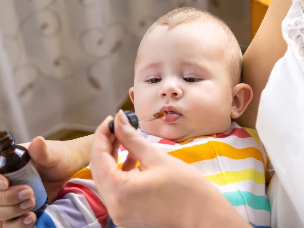 annesi bebeğin ağzına ocean d vitamini damlatıyor