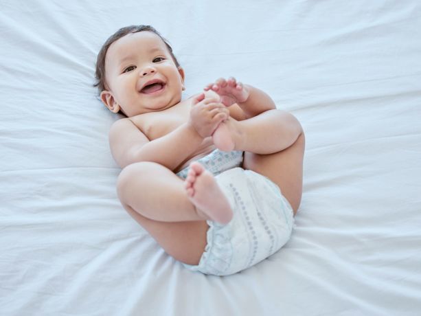 Bebek bezi ile mutlu görünen gülümseyen bebek