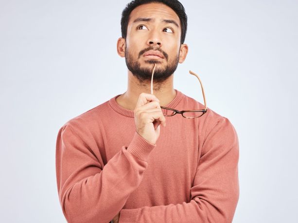  Gri arka plan üzerinde bir adam sorular soruyor ve beyin fırtınası yapıyor.