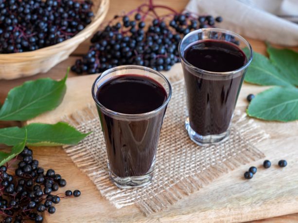 masanın üstünda mürver bitkisi ve  mürverden yapılan besinler ve içecekler gözüküyor