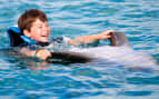 Boy swimming with the dolphins in Mexico