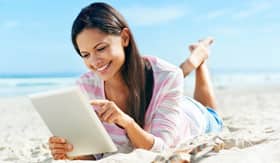 Woman with iPad on beach