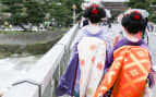 Geisha walking on a bridge in Arashiyama Japan