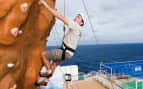 NCL Guest climbing the rockwall Norwegian Cruise