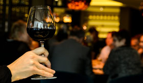 A Celebrity Cruises guest enjoying red wine in a winery lounge in Ensenada.