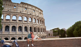 Couple sitting by the Colosseum in Rome