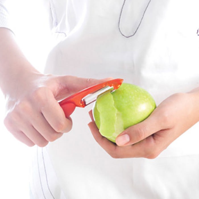 Personne en train d'éplucher une pomme