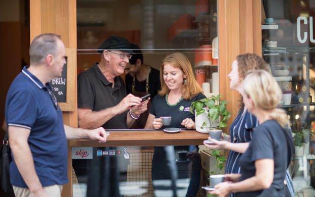 Tourists enjoying coffee at a charming Melbourne café, sharing laughter and smiles, creating unforgettable memories together.