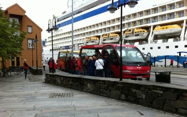 Passengers enjoying City Sightseeing Stavanger: Hop-On, Hop-Off mini buses lined up, offering convenient exploration of the city's attractions.