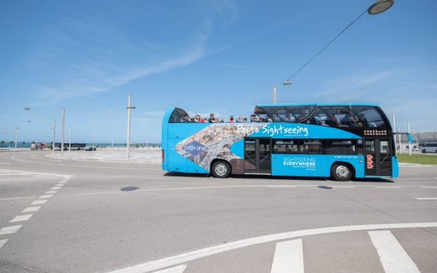 Gray Line Porto Hop-On Hop-Off bus gracefully navigating the serene streets of Porto, offering a peaceful exploration experience.