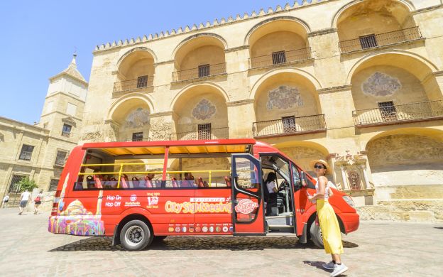 Young traveler eagerly boarding the City Sightseeing Cordoba Hop-On, Hop-Off bus, full of anticipation for city exploration.