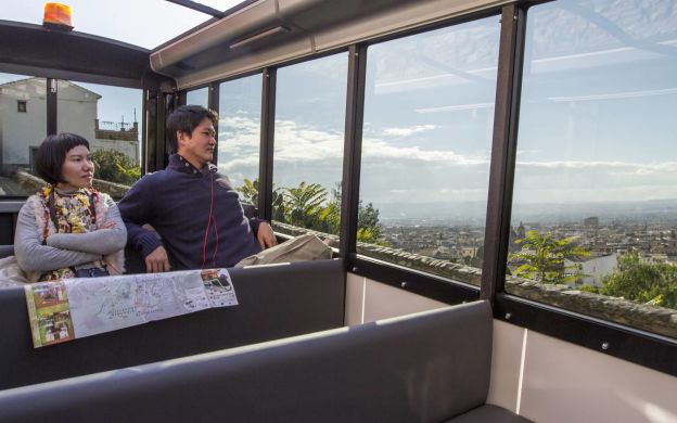 Passengers immersed in the captivating sightseeing experience from the Granada City Tour Train, embracing the beauty of the city's landmarks.