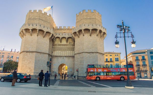 Hop-On, Hop-Off bus patiently awaits passengers at renowned Valencia attraction, ready to embark on a memorable adventure.