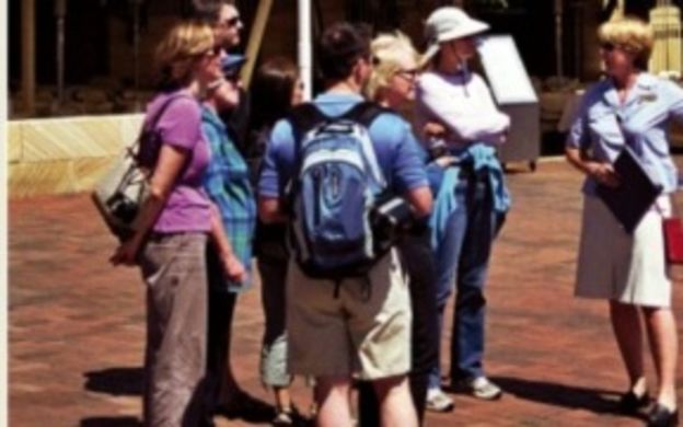 Enthusiastic tourists joyfully engage in Sydney's original Rocks tour, captivated by the history and charm of the area.
