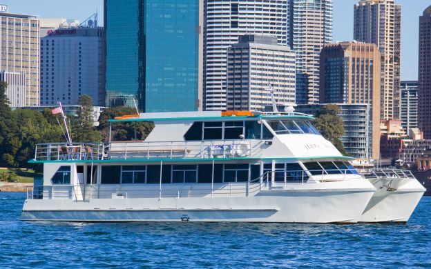 A cruise ship rests serenely on the sea, embraced by a stunning cityscape, creating a captivating fusion of maritime and urban beauty.