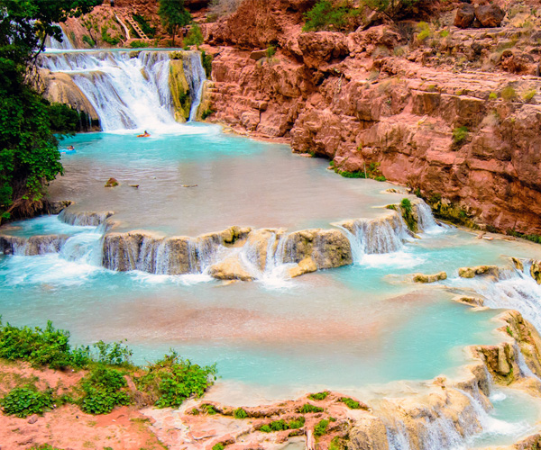 Pools of turquoise water cascade into falls below