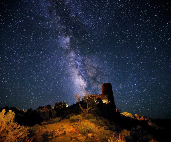Mary Colter's watchtower at the Grand Canyon is illuminated from above by millions of stars and the Milky Way