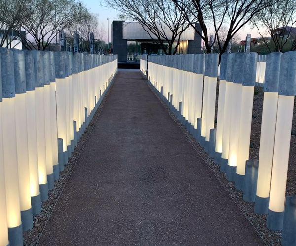 Poles lit up at dusk, each representing a life lost aboard the USS Arizona