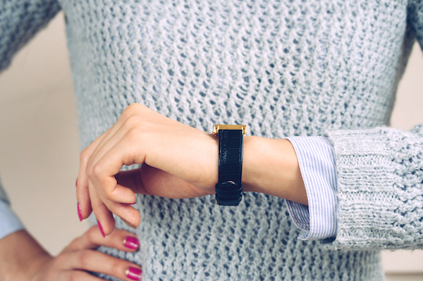 Woman checking her watch with hand on hip