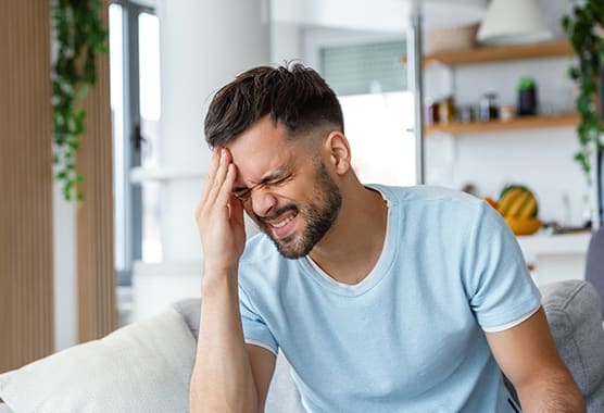 A stressed, exhausted teen holding their head in frustration