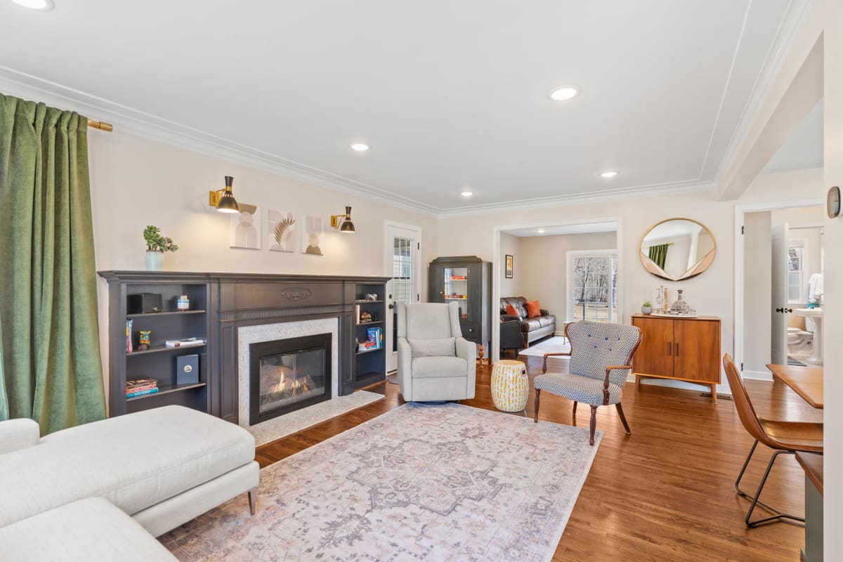 A cozy and stylish living room featuring a black fireplace and a blend of modern furnishings.